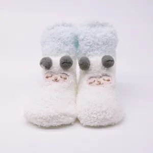 Detailed view of cute plush baby socks with cartoon embroidery and soft pom-pom details