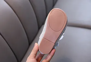Detailed view of the anti-slip rubber outsole on a girl's silver glittery princess flat shoe