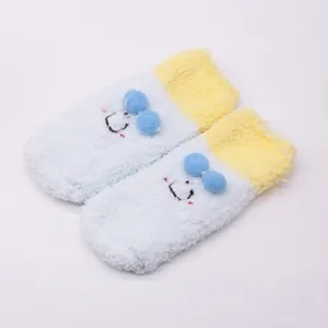 Detailed macro view of soft fluffy cartoon baby floor socks featuring cute blue pom-poms