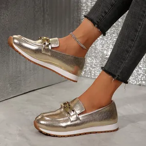Detailansicht eleganter goldener Metallic-Plateau-Loafer mit dekorativer Kettenschnalle