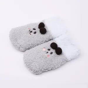 Detailed view of cute plush baby socks featuring a cartoon bear face and fuzzy texture