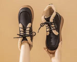 Detailed view of black snow boots with warm cream shearling lining and lace-up design.