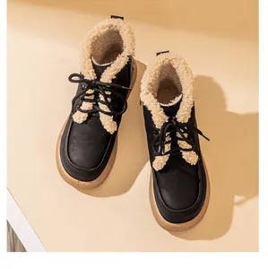 Close-up of warm black snow boots with plush faux shearling lining and lace-up front.