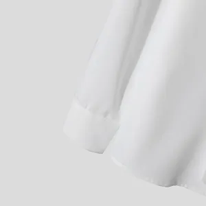 Detail macro of white formal shirt cuff and hem showing clean fabric texture