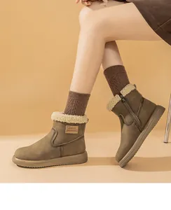 Detailed view of brown snow boots with plush lamb wool lining and side zipper.