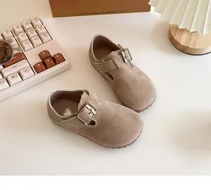 Close-up of khaki suede toddler walking shoes with adjustable vintage metal buckle closure