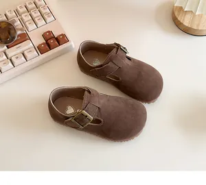 Brown suede baby walking shoes with buckle strap, British style detail view.