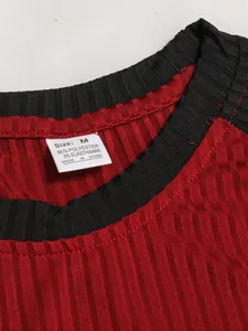 Dettaglio della trama a costine rosse e dell'etichetta di un t-shirt da uomo slim