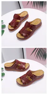 Detail view of women's burgundy wedge sandals with thick soles and laser-cut patterns.