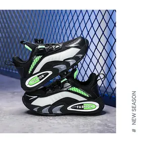 Detailed side view of breathable black and green boys' sports shoes with mesh texture.