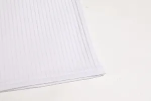 Dettaglio dell'orlo in tessuto a costine bianco di una maglietta a maniche lunghe da uomo