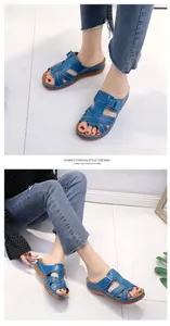 Detail view of blue cross-strap wedge sandals with white stitching on female model
