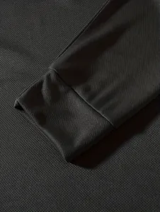 Close-up of breathable mesh fabric texture and cuff detail on black men's long sleeve shirt