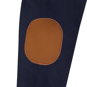 Macro detail showing navy blue ribbed jacket sleeve with brown oval elbow patch.