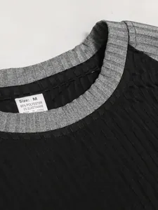 Primo piano di un girocollo di maglietta a coste nero e grigio con etichetta