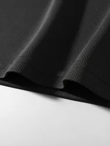 Detailed macro shot of breathable black mesh fabric texture for men's base layer.