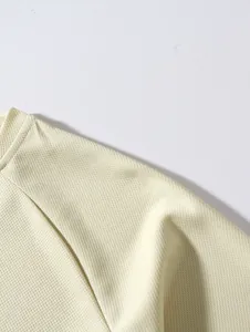 Macro view of men's mesh base layer showing breathable fabric texture and collar