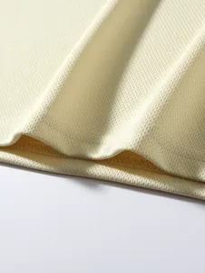 Macro view of the breathable cream colored mesh fabric and double stitched hem detail