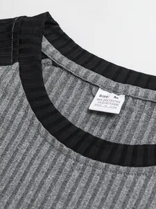 Dettaglio ravvicinato di una t-shirt grigia a coste da uomo con colletto nero ed etichetta