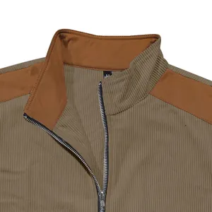 Detailed view of the stand collar and silver metal zipper on a khaki patchwork jacket