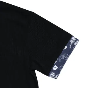 Close-up of black corduroy sleeve with blue paisley print cuff on men's Henley shirt.