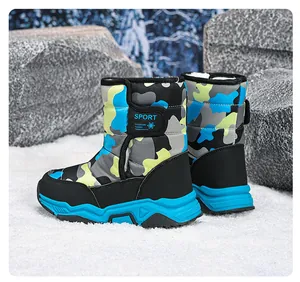 Detalle de botas de nieve de camuflaje para niños con suelas azules antideslizantes.