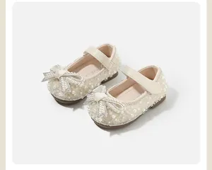 Close-up of baby girl princess shoes with exquisite pearl and rhinestone bow details