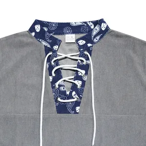 Detail view of grey corduroy shirt with paisley lace-up V-neckline and fabric texture