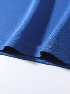 Macro detail of breathable blue mesh fabric on men's long-sleeve crew neck base layer