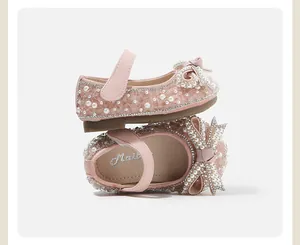 Close-up detail of pink toddler princess shoes decorated with pearls and rhinestone bows