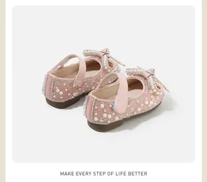 Close-up detail shot of pink baby girl princess shoes with pearls and rhinestone bows