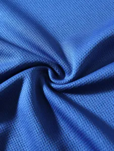 Macro view showing the breathable blue mesh fabric texture of a men's undershirt.