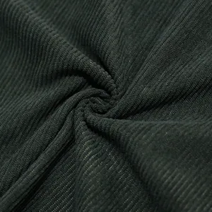Close-up view of heavy dark green corduroy fabric showing ribbed texture and detail