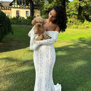 Elegant off-the-shoulder white lace hollow maxi dress with long sleeves in garden setting