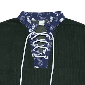 Detailed macro view of lace-up Henley collar with blue paisley pattern on corduroy fabric