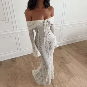Close-up of white off-the-shoulder lace maxi dress with delicate floral patterns