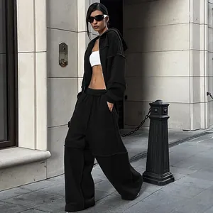 Ensemble de survêtement noir chic pour femme avec veste à capuche et pantalon large taille haute.