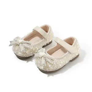 Elegant cream baby girl Mary Jane shoes with pearl bows and sparkly rhinestone details.