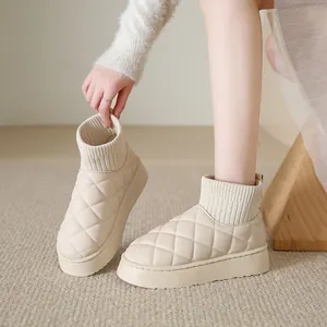 Close-up of beige quilted snow boots with thick soles and ribbed knit ankle collars