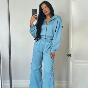 Ensemble de survêtement bleu clair deux pièces avec veste à capuche et pantalon large.