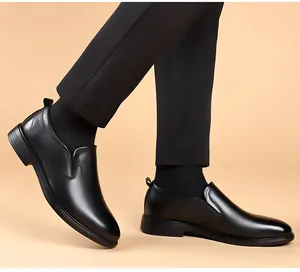 Gros plan de chaussures en cuir formelles noires pour hommes, semelle souple et sans lacets.