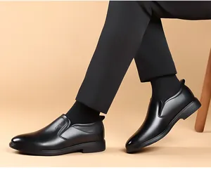 Vue latérale de mocassins en cuir noir pour homme avec pantalon de costume sur fond beige