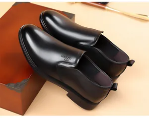 Vue détaillée de mocassins élégants en cuir noir pour hommes sur une boîte.