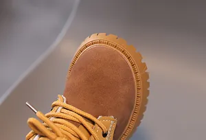 Detail view of the durable round toe and suede texture on children's tan Martin boots