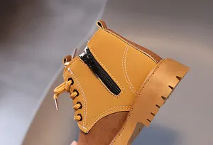 Detailed close-up of yellow children's Martin boots with side zipper and white stitching