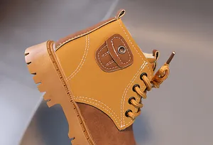 Macro detail of children's warm Martin boots with white stitching and rubber sole
