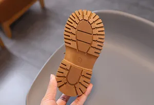 Detailed view of the brown non-slip rubber sole for children's Martin boots, size 25