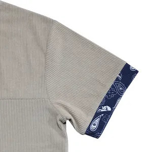 Close-up detail showing the corduroy texture and paisley pattern on the shirt sleeve