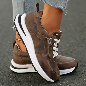 Λεπτομέρεια από καφέ vintage γυναικεία sneakers με πλατφόρμα, φερμουάρ και κορδόνια.