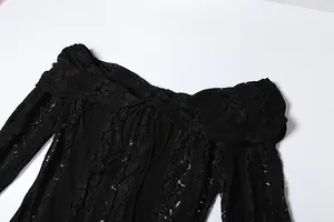 Close-up of black off-the-shoulder lace dress with hollow-out pattern and tie-up detail